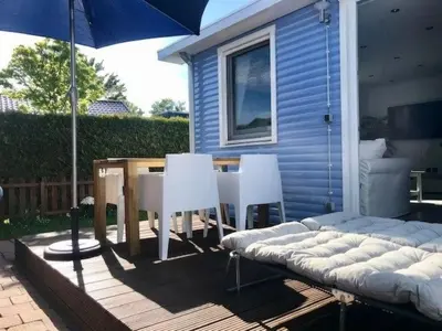 a patio with a table and chairs and an umbrella at Holiday Home Haus DE BLAUWE REIGER by Interhome in Wervershoof