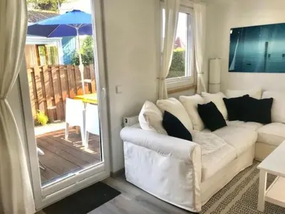 a living room with a white couch and a sliding glass door at Holiday Home Haus DE BLAUWE REIGER by Interhome in Wervershoof