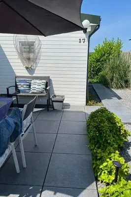 a patio with an umbrella and a table and a bench at Apartment Tami by Interhome in Wervershoof