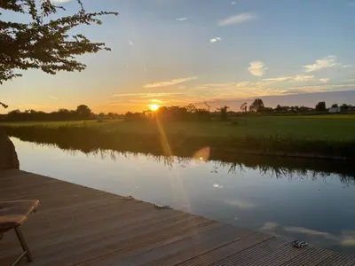 a sunset over a lake with a wooden dock at Apartment Tami by Interhome in Wervershoof