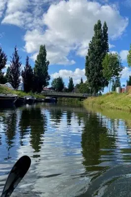 a person is paddling a canoe on a river at Apartment Tami by Interhome in Wervershoof