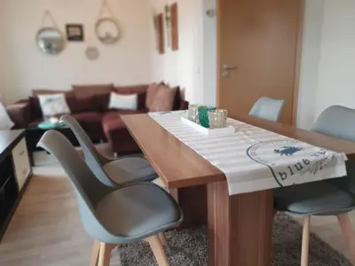 a living room with a wooden table and two chairs at Holiday Home in Wervershoof mit Sonniger Terrasse by Interhome in Wervershoof