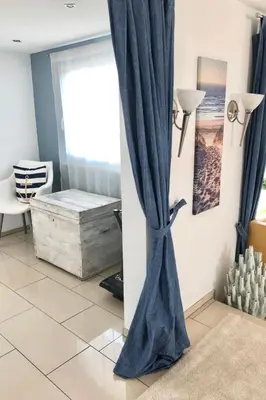 a blue curtain in a room with a window at Holiday Home direkt am See by Interhome in Wervershoof