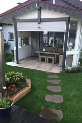 a patio with a picnic table in a yard at Holiday Home direkt am See by Interhome in Wervershoof
