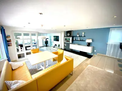 a living room with a yellow couch and a table at Holiday Home direkt am See by Interhome in Wervershoof