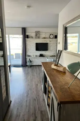 a living room with a television and a wooden floor at Holiday Home Haus Good Times by Interhome in Wervershoof
