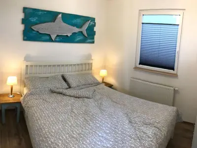 a bedroom with a bed with a fish painting on the wall at Holiday Home Haus Good Times by Interhome in Wervershoof
