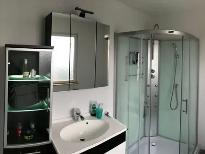 a bathroom with a sink and a glass shower at Holiday Home Haus Good Times by Interhome in Wervershoof