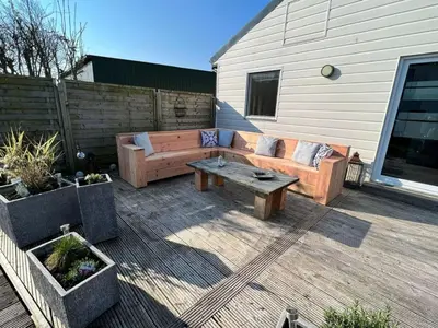 a patio with a couch and a coffee table at Holiday Home Haus Good Times by Interhome in Wervershoof