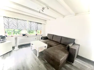 a living room with a couch and a table at Apartment Familienfreundliches Ferienhaus Angel mit Garten by Interhome in Wervershoof
