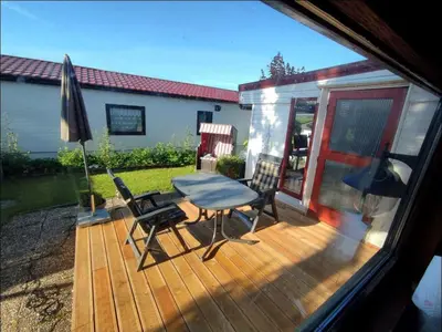 a wooden deck with a table and chairs and an umbrella at Apartment Het kleine Hemeltje by Interhome in Wervershoof