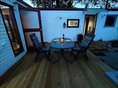 a patio with a table and chairs on a deck at Apartment Het kleine Hemeltje by Interhome in Wervershoof