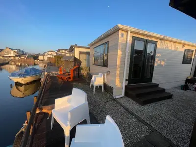 a tiny house on a dock next to the water at Apartment Chalet Welcome direkt am Wasser mit eigenem Steig by Interhome in Wervershoof
