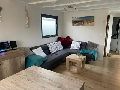 a living room with a couch and a table at Apartment Chalet Welcome direkt am Wasser mit eigenem Steig by Interhome in Wervershoof