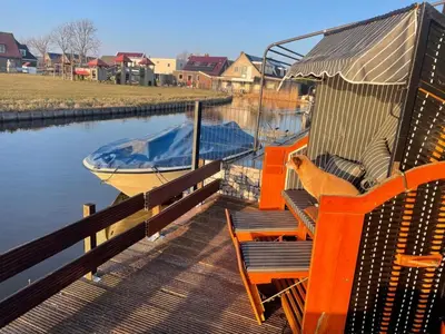 a dog sitting on a bench next to a boat at Apartment Chalet Welcome direkt am Wasser mit eigenem Steig by Interhome in Wervershoof