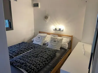 a small bedroom with a bed with two white pillows at Apartment Chalet Welcome direkt am Wasser mit eigenem Steig by Interhome in Wervershoof