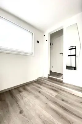 an empty room with a large window and wooden floors at Holiday Home Luna by Interhome in Wervershoof