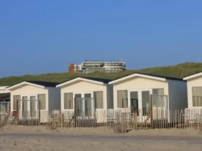 a row of houses on the beach withgrass at Holiday Home Strandhaus direkt am Meer by Interhome in Wijk aan Zee