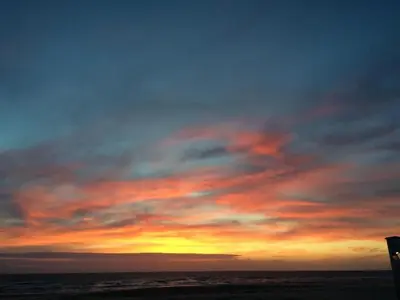 a sunset on the beach with a cloudy sky at Holiday Home Strandhaus direkt am Meer by Interhome in Wijk aan Zee
