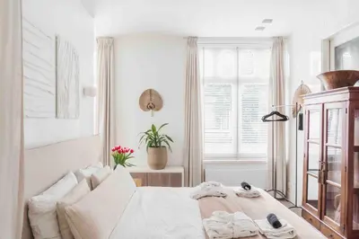 a white bedroom with a bed and a window at Cozy Traditional Dutch City Apartment close to Amsterdam & Tulips in Purmerend