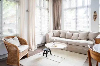 a living room with a couch and a table at Cozy Traditional Dutch City Apartment close to Amsterdam & Tulips in Purmerend