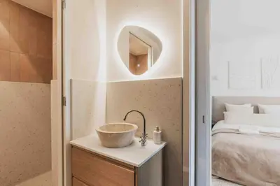 a bathroom with a bowl sink on a table next to a bed at Cozy Traditional Dutch City Apartment close to Amsterdam & Tulips in Purmerend