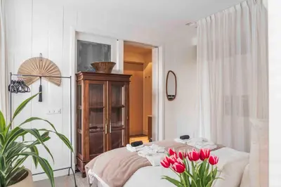 a room with a bed with red tulips in it at Cozy Traditional Dutch City Apartment close to Amsterdam & Tulips in Purmerend