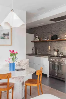 a kitchen with a table and two chairs and a stove at Cozy Traditional Dutch City Apartment close to Amsterdam & Tulips in Purmerend