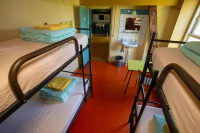 two bunk beds in a room with a kitchen at Strowis Hostel in Utrecht