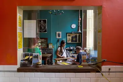 two people sitting at a counter in a store at Strowis Hostel in Utrecht