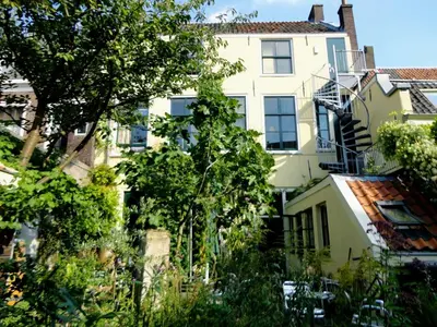 a tall white building with a balcony at Strowis Hostel in Utrecht