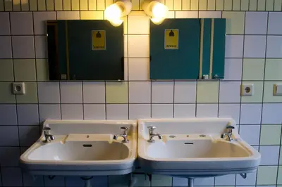 two sinks in a public bathroom with mirrors at Strowis Hostel in Utrecht