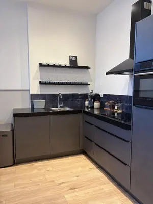 a kitchen with black counters and a sink at Alkmaar Signature Stay -Boutique Apartment in Alkmaar