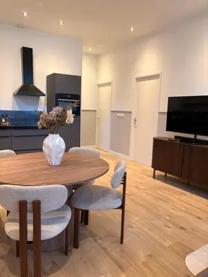 a dining room with a table and chairs and a tv at Alkmaar Signature Stay -Boutique Apartment in Alkmaar