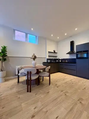 a living room with a table and a kitchen at Alkmaar Signature Stay -Boutique Apartment in Alkmaar