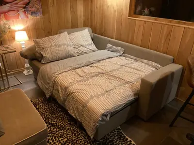a bed in a room with a couch at B&B Tuinhuis Vianen in Vianen