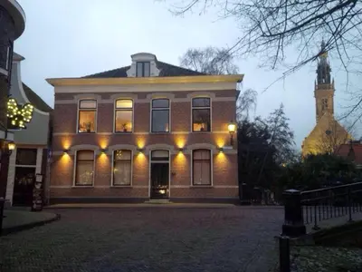 a large brick building with a clock tower in the background at Unique B&B, in the Historic City Centre of Edam in Edam