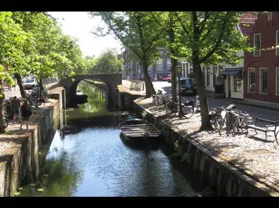a group of boats in a river in a city at Unique B&B, in the Historic City Centre of Edam in Edam