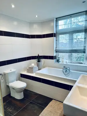 a bathroom with a tub and a toilet and a window at Unique B&B, in the Historic City Centre of Edam in Edam