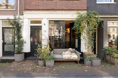 a dog sitting on a bench in front of a building at Canal house Egelantiersgracht with private garden in Amsterdam