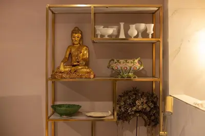 a shelf with a statue of a buddha on it at Canal house Egelantiersgracht with private garden in Amsterdam