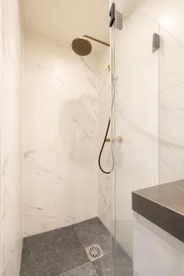 a bathroom with a shower with a glass door at Canal house Egelantiersgracht with private garden in Amsterdam