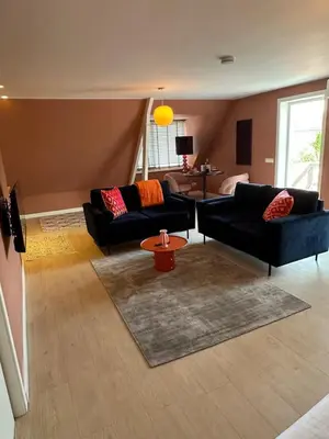 a living room with two couches and a table at Little Village - Noordwijkerhout in Noordwijkerhout