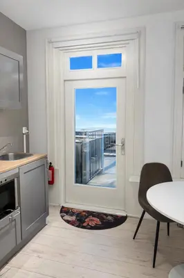 a kitchen with a door leading to a balcony at Maison Lumière - Private Rooftop terrace in Amsterdam