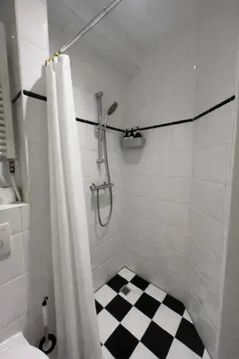 a bathroom with a shower with a black and white checkered floor at Maison Lumière - Private Rooftop terrace in Amsterdam