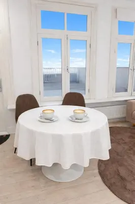 a white table with two cups on it in a room with windows at Maison Lumière - Private Rooftop terrace in Amsterdam