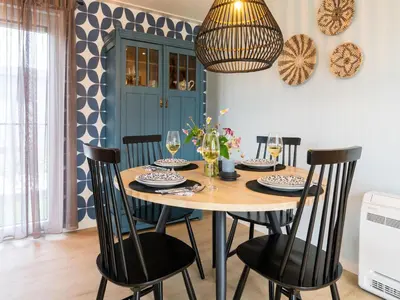 a dining room table with chairs and a chandelier at Bij de Bakker in Oud-Ade