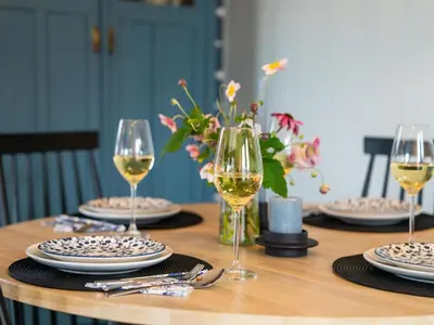 a table with glasses of wine and plates on it at Bij de Bakker in Oud-Ade