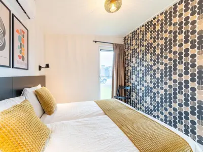 a bedroom with a bed and a tile wall at Bij de Bakker in Oud-Ade