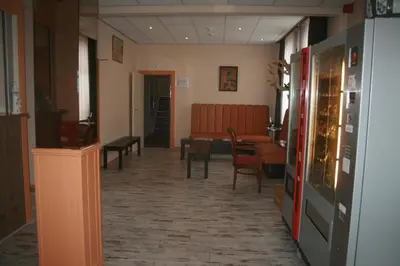 a hallway with a table and chairs in a room at Zorn Hotel Duinlust in Noordwijk aan Zee